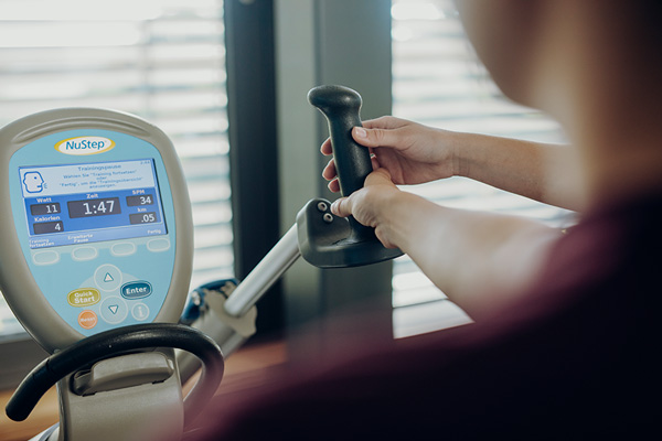Ein Therapeut erklärt die Bedienung eines Trainingsgerätes. Ein Therapeut erklärt die Bedienung eines Trainingsgerätes.